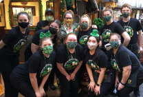 Group photo of Cloverleaf team, all wearing black with green masks