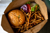 burger, fries, and condiments in takeout box